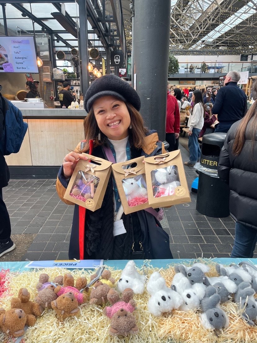 Customer holding three boxed HaloZen plushes at a market